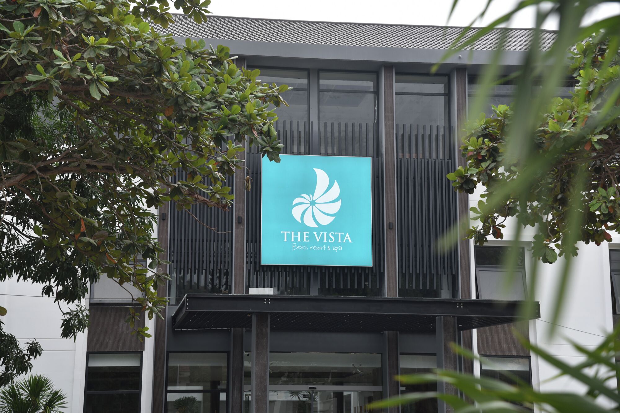 A modern building with a sign that reads "The Vista Beach Resort & Spa".
