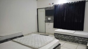 A bedroom with a bed, a bench, a shower area, and a tiled floor. - khodal Resort (Girgadhada)