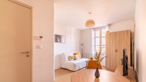 Ein modernes Wohnzimmer mit einer Couch, einem Esstisch und einem Fernseher.