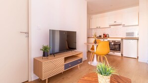 Eine moderne Küche mit weißen Schränken, einer Mikrowelle und einem kleinen Backofen.