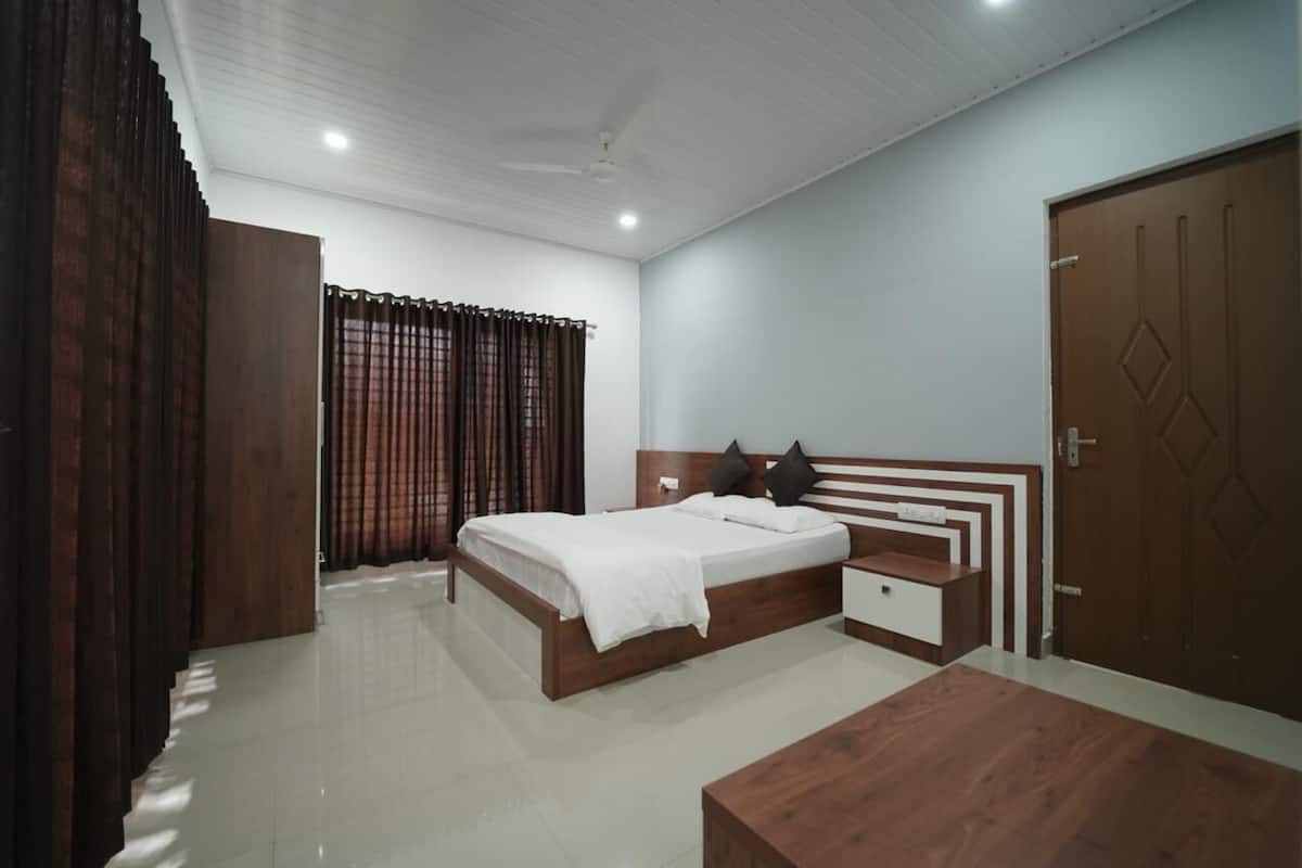 A bedroom with a wooden bed, a nightstand, a wooden bench, and a wardrobe.