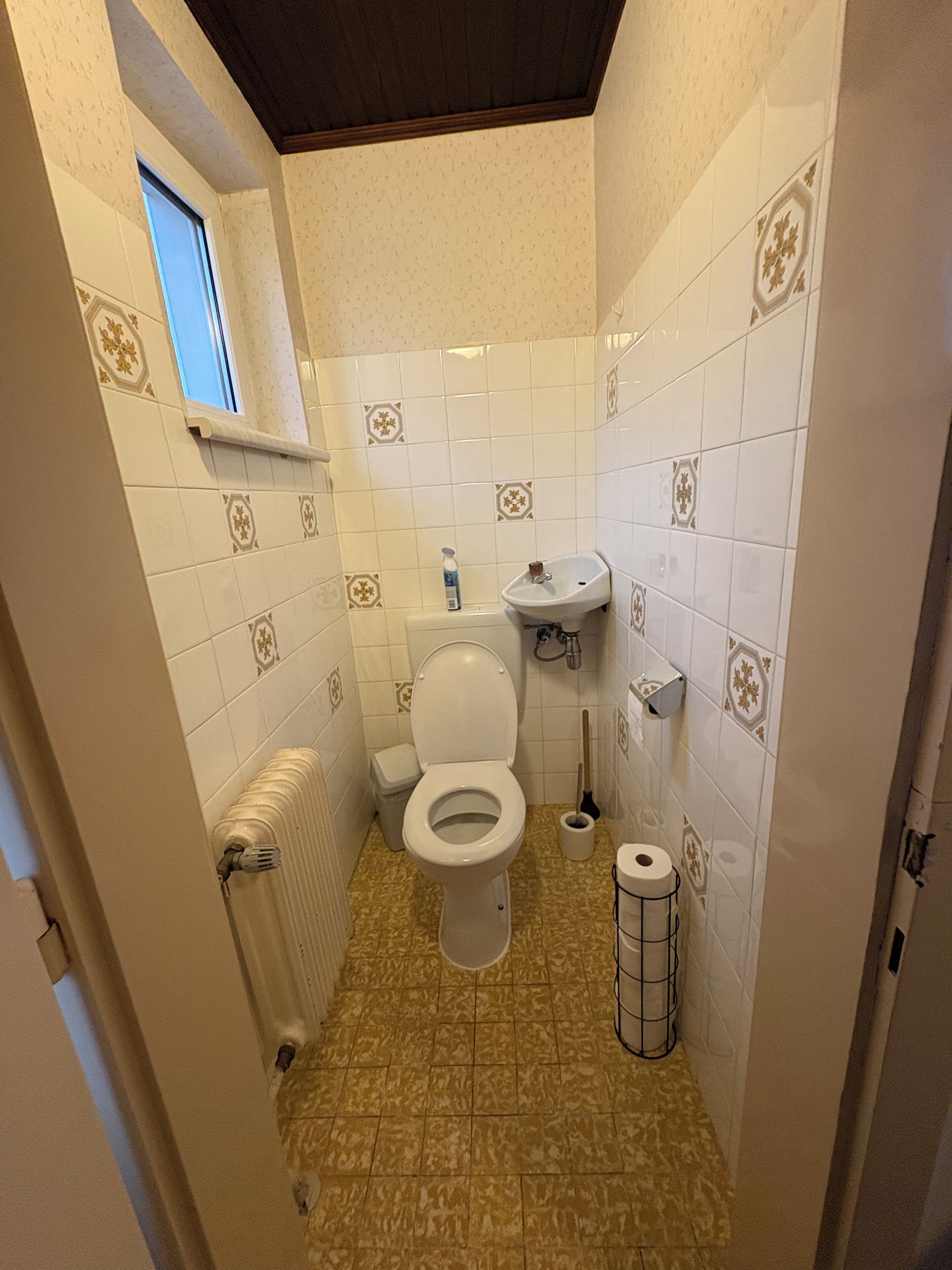 Un baño pequeño con inodoro, lavabo y radiador.