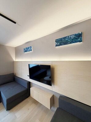 Apartamento superior, para não fumantes | Área de estar | Smart TV 55 polegadas com canais digitais