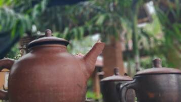 A rustic wooden table with a clay teapot and a matching cup.