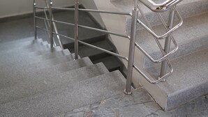 Eine Treppe mit Metallgeländern und Steinpodesten.