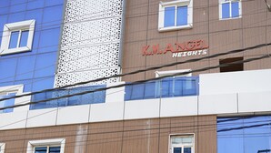 Ein Gebäude mit einem Schild, das 'Dwaraka Heaven' bewirbt und klimatisierte Luxuszimmer anzeigt.