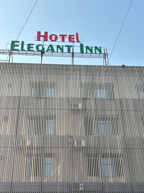 A hotel sign with the name "Hotel Elegant Inn" on a metal facade. - Hotel Elegant inn- Ichhapore (Surat)