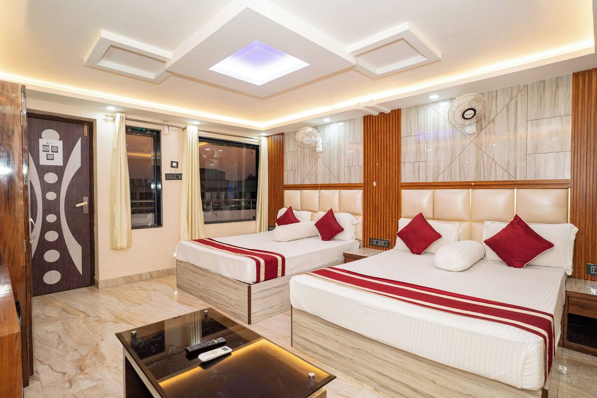 A hotel room with two beds, a ceiling fan, a marble floor, and a modern design.