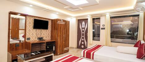 A hotel room with two beds, a TV, a wardrobe, and a window with curtains.