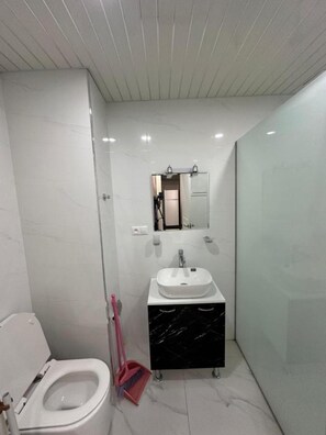 Ein modernes Badezimmer mit Toilette, Waschbecken und Duschbereich.
