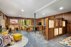 A cozy indoor space with a pool table, a dartboard, and a billiards table.