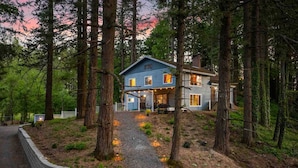 A two-story house with a covered porch and a gravel driveway leading to the entrance. - Wonderful Forested Retreat, Hot Tub, Pet Friendly, Game Room, Pool Table, Fire-Pit, on 2 Acres (Gresham)