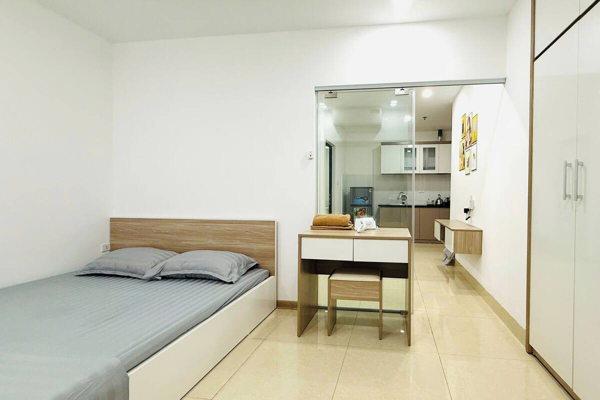 Een moderne slaapkamer met een bed, een bureau en een kledingkast.