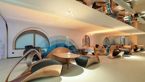 Ein stilvoller Lounge-Bereich mit außergewöhnlichen, geschwungenen Sitzgelegenheiten und einem zentralen Tisch, der einen modernen Look und viel Platz zum Entspannen bietet.