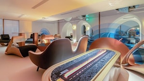 Eine moderne Hotelhalle mit zeitgemäßen Möbeln, einer zentralen Sitzecke und einem architektonisch besonderen Design mit Bögen.