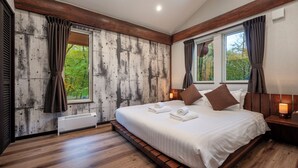 A bedroom with a large bed, wooden floor, and a view of trees through the windows. - Chise Fukuro by H2 Life (Furano)