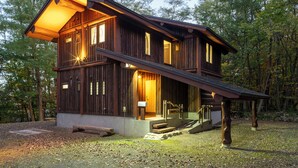 A two-story wooden cabin with a porch and a ramp leading to the entrance. - Chise Fukuro by H2 Life (Furano)