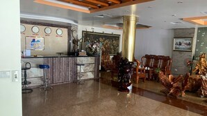 A lobby with a reception desk, bar stools, and traditional wooden furniture. - Duc Trung Hotel CB by Bayluxury (Thuc Phan)