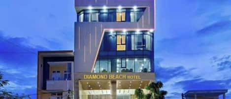 A multi-story hotel with a modern design, featuring a prominent sign at the top and a well-lit entrance.