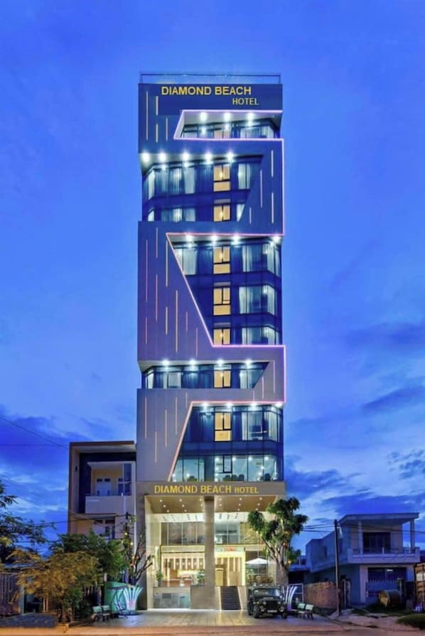 Et moderne hotel med flere etager, med et tydeligt skilt øverst og en veloplyst indgang.