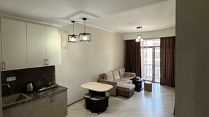 Un appartement moderne comprenant une cuisine, un coin repas et un salon.