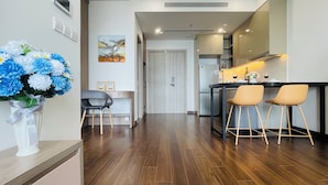 Une cuisine moderne avec un coin repas, un plancher en bois et un vase de fleurs.
