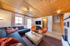 A modern living room with a sofa, two armchairs, a coffee table, and a television. - Premium Mountain Chalet for 10 (Wald-Königsleiten)