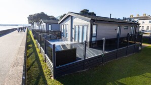 A row of seaside mobile homes with a deck and a view of the sea. - The Great Escape - a frontline lodge overlooking Avon Beach (Mudeford)