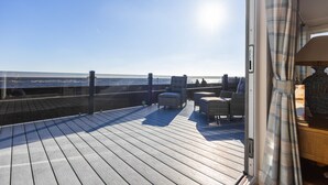 A wooden deck with wicker furniture, overlooking the ocean. - The Great Escape - a frontline lodge overlooking Avon Beach (Mudeford)