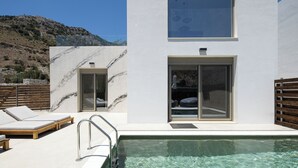 A modern building with a pool, a wooden deck, and a mountain in the background. - Imbros Villas Free* Heated Pools in mountains! (Crete)