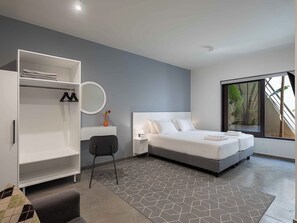 Een moderne slaapkamer met een bed, een kledingkast, een bureau en een groot raam.