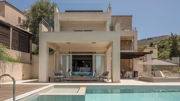 A modern two-story building with a pool area, outdoor seating, and a view of the surrounding landscape. - Adeste Seaview Villas Double - 2 Pools,900m to sea (Chania)