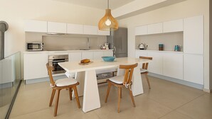 A modern kitchen with white cabinetry, a central island, and a hanging pendant light. - Adeste Seaview Villas Double - 2 Pools,900m to sea (Chania)