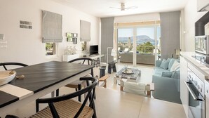 A modern living room with a dining area, large windows, and a view of the outdoors. - Adeste Seaview Villas Double - 2 Pools,900m to sea (Chania)