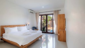 Una habitación de hotel moderna con una cama de madera, un televisor de pantalla plana y un ventanal corredero que da a un espacio exterior.