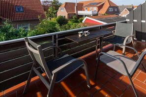 Enjoy a peaceful moment on this rooftop terrace with a view of the surrounding houses.