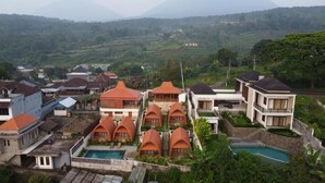 Un resort con varias cabañas, una piscina y vistas del paisaje circundante.