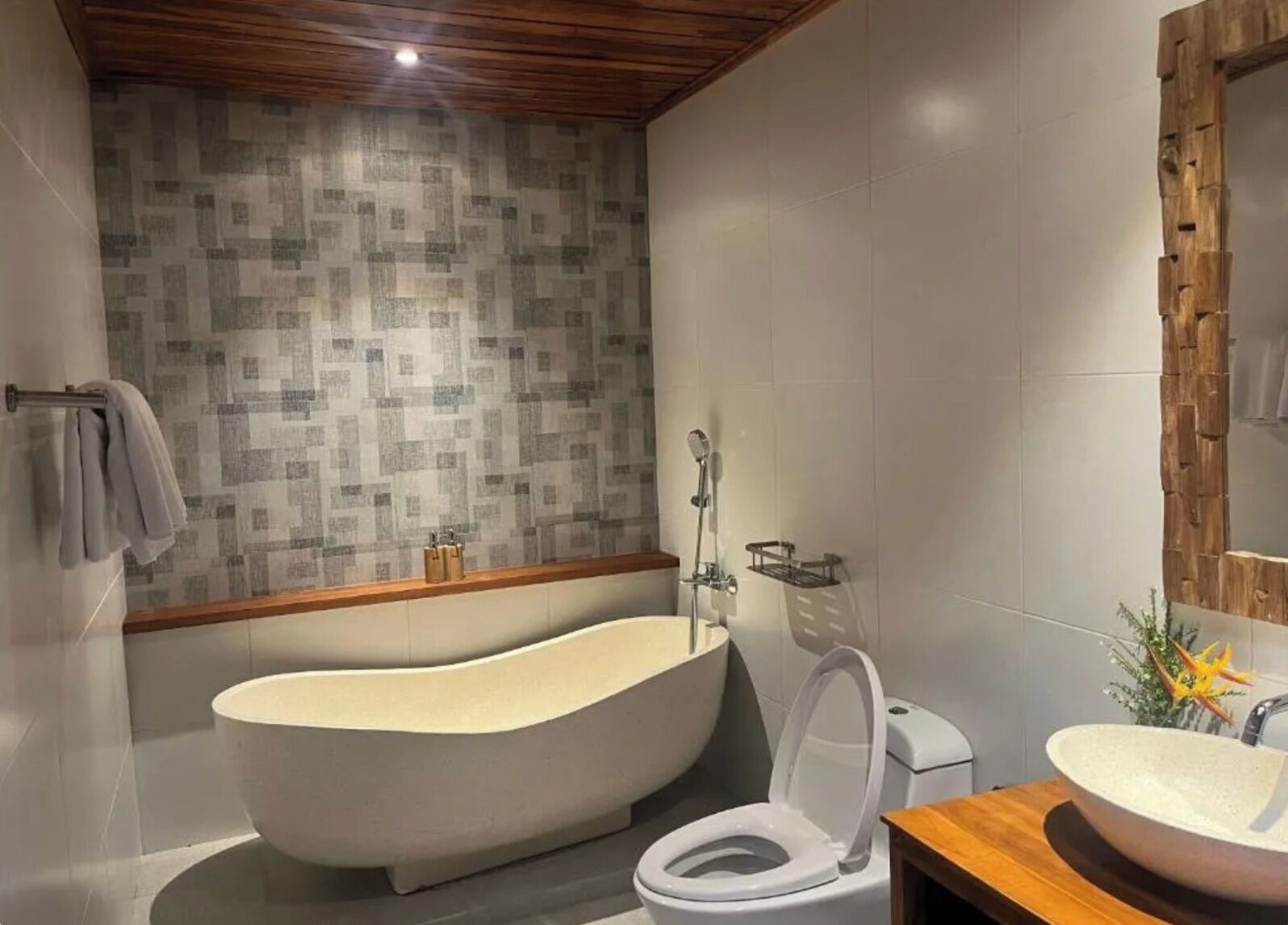 Ein modernes Badezimmer mit freistehender Badewanne, Toilette und Waschbecken.