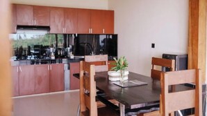 Una cocina moderna con armarios de madera y una mesa de comedor con sillas.