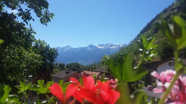 A mountain landscape with a clear sky, houses, and greenery in the foreground. - Garni Marianne (Malles Venosta)