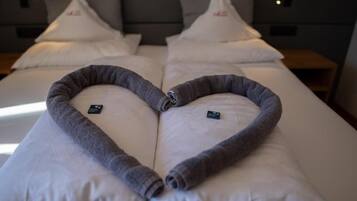 Een hotelkamer met twee bedden, elk versierd met handdoeken in de vorm van een hart.