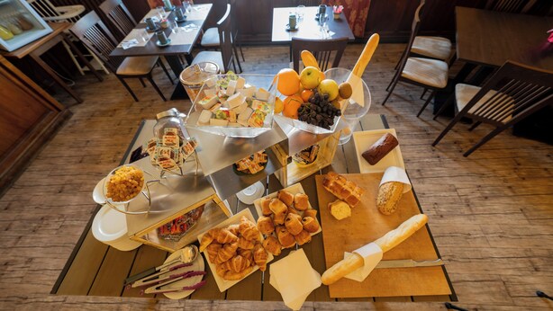 Een ontbijtbuffet met diverse gebakjes, fruit en beleg.