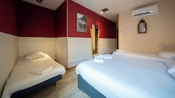 A hotel room with a large bed, a smaller bed, and a mirror.