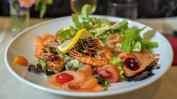 Une assiette de nourriture contenant des crevettes, du saumon et des légumes.