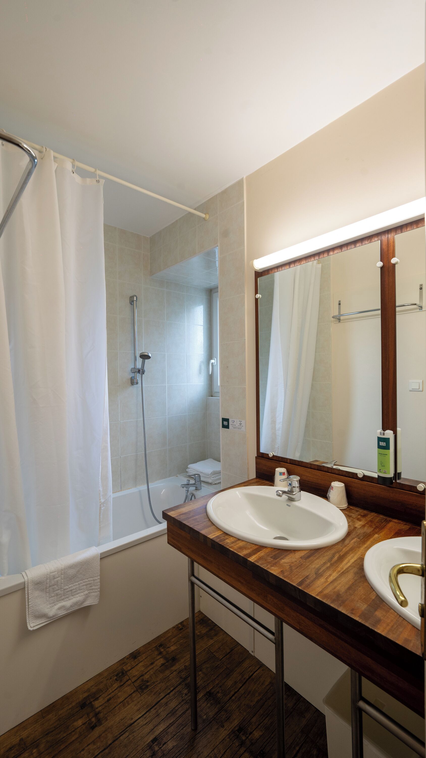 Ein Badezimmer mit Dusche, Waschbecken und Spiegel.