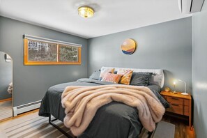 A bedroom with a bed, bedside table, and a nightstand. - Walking Distance to Downtown Bozeman (Bozeman)