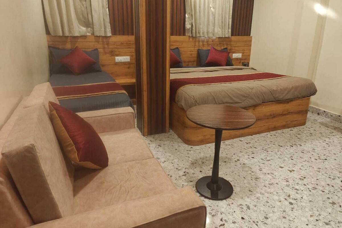Un dormitorio con una cama de madera, un sofá y una pequeña mesa redonda.
