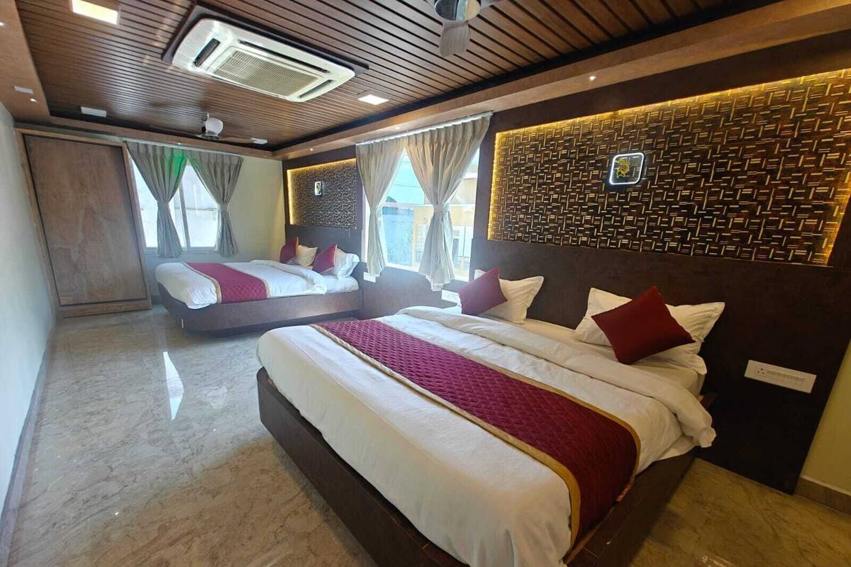 Habitación de hotel con dos camas, techo de madera y pared con diseño.
