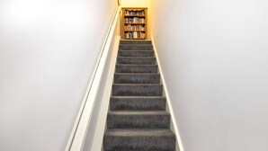 Una scala con gradini rivestiti di moquette che conduce a una libreria.