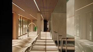 A modern interior with a long corridor, benches, and glass doors. - Nickel Resort & Wellnest Grzybowo (Grzybowo)